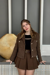 a lady in a brown jacket and a brown high-waist skirt